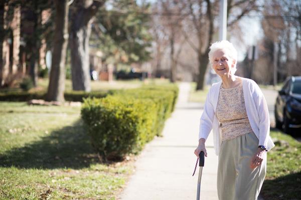 senior female walking on sidewalk