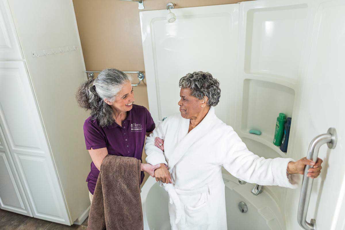 A caregiver helps a senior to safely get to the shower