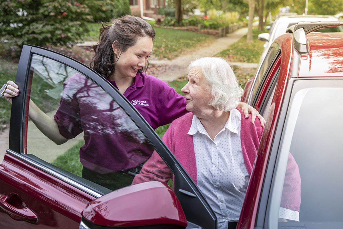 Caregiver helping a senior our of a car