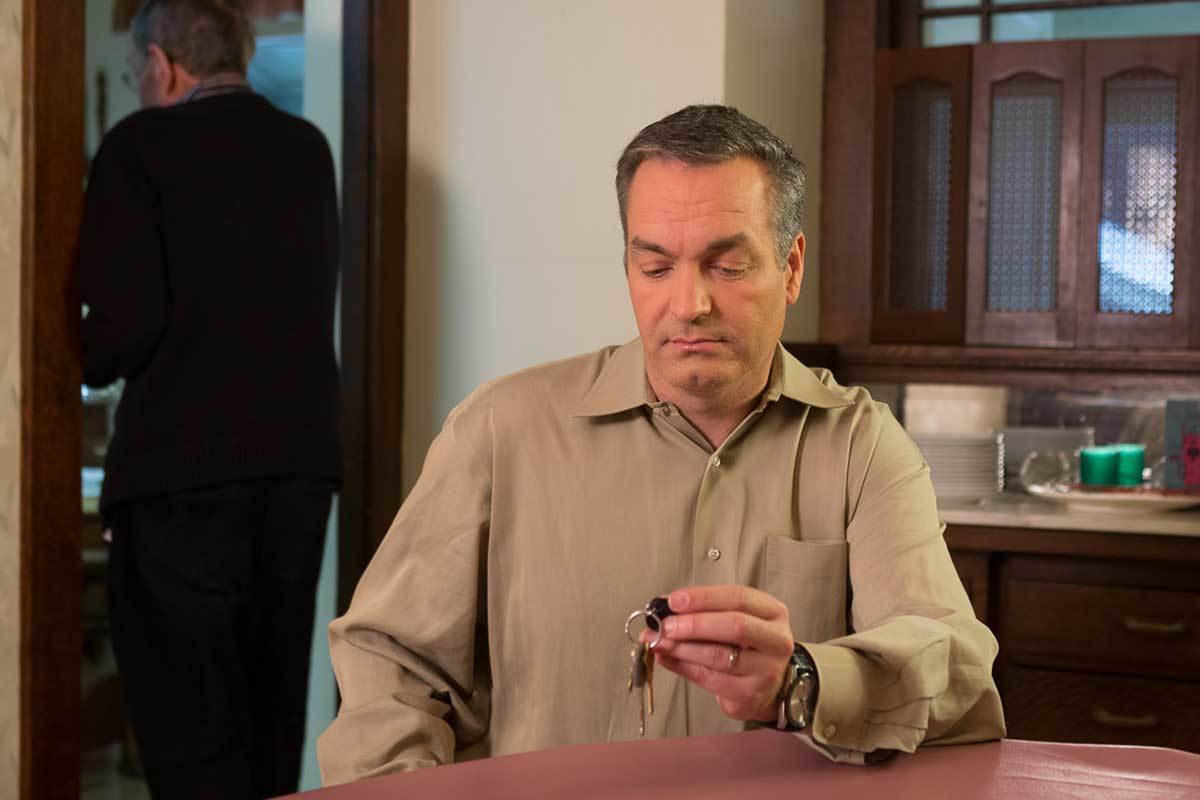 Man sitting at kitchen table with car keys in hand