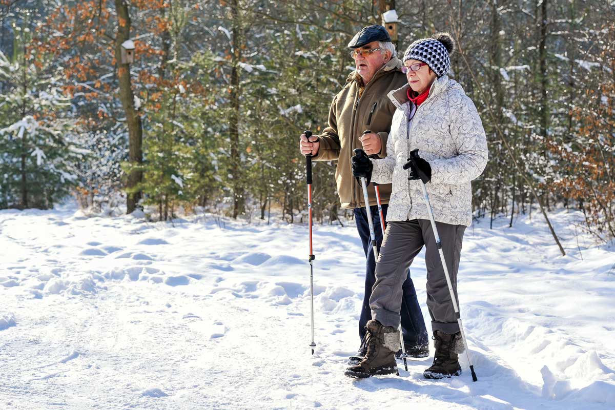 Senior and caregiver nordic pole walking