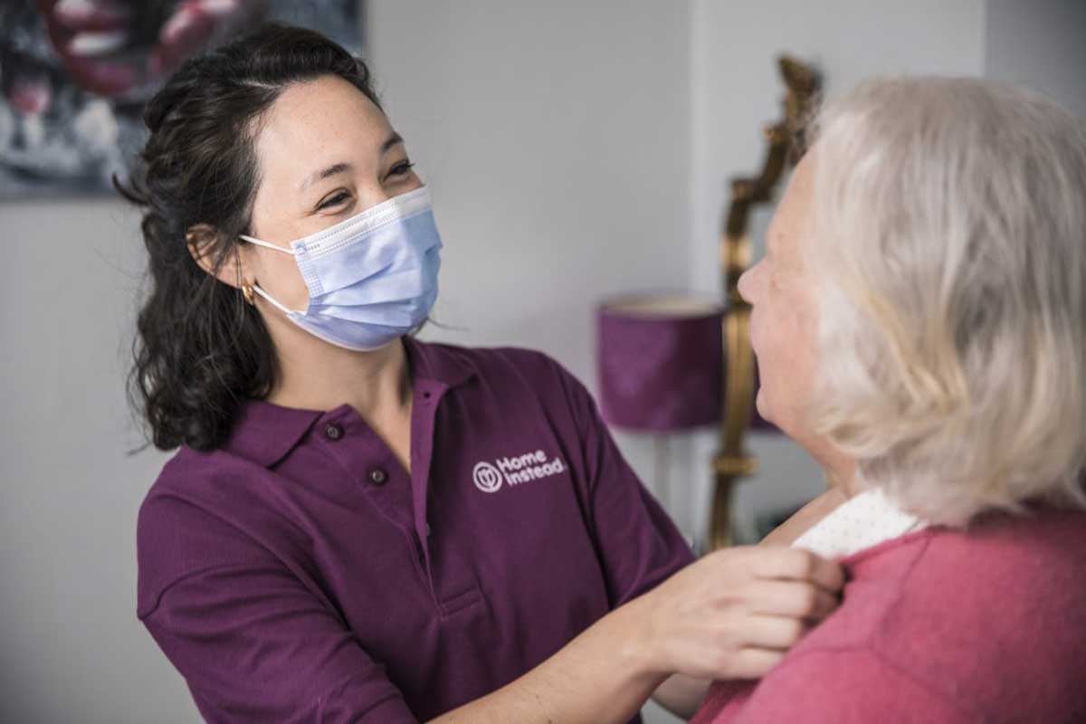 Caregiver helps grooming lady senior