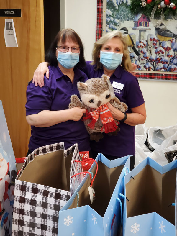 Care Professionals holding a stuffed owl for a gift