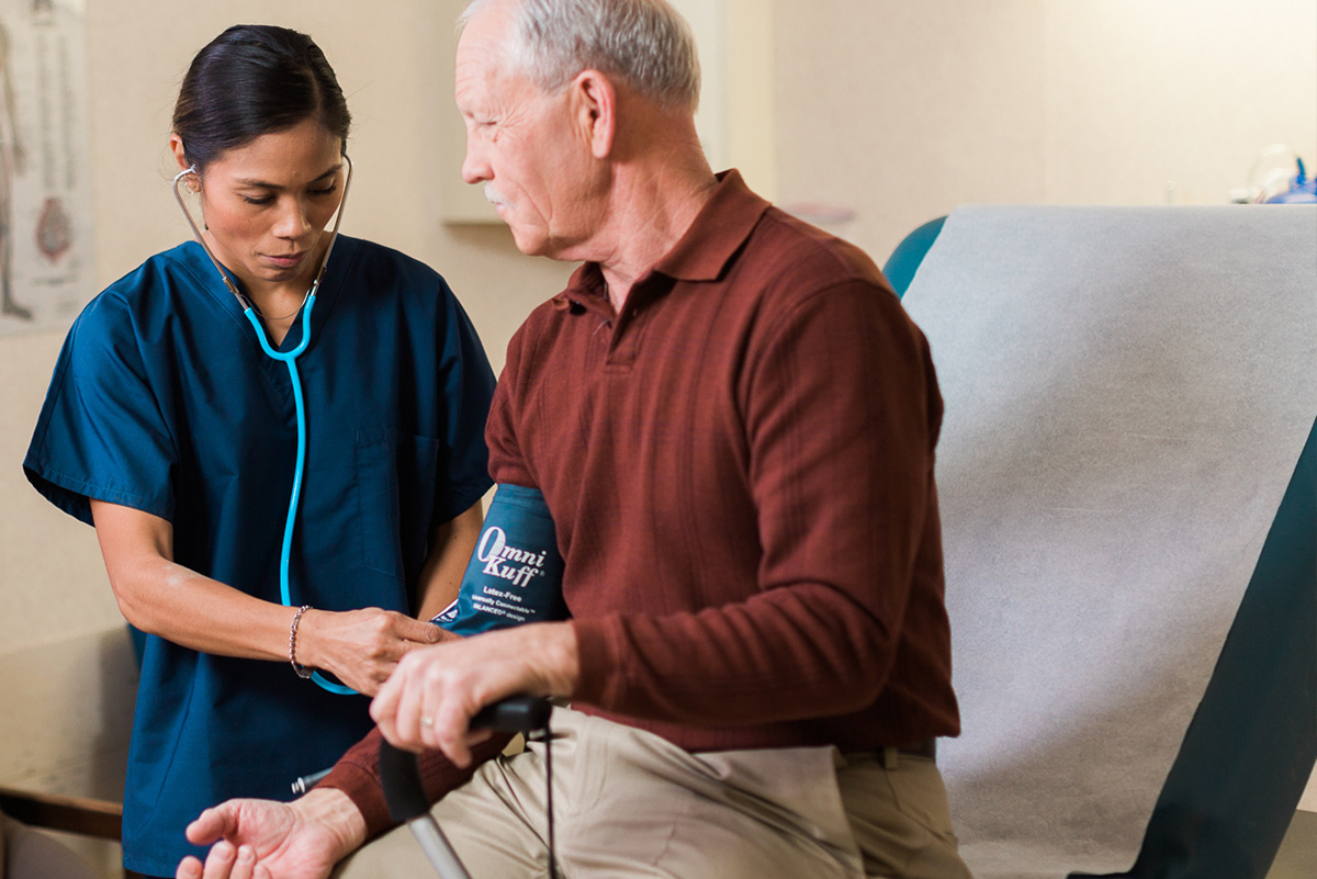 Senior man having blood pressure checked