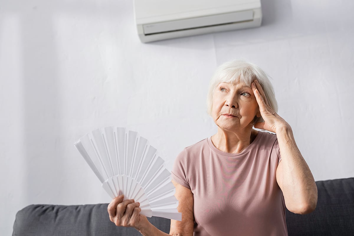 older woman with handheld fan