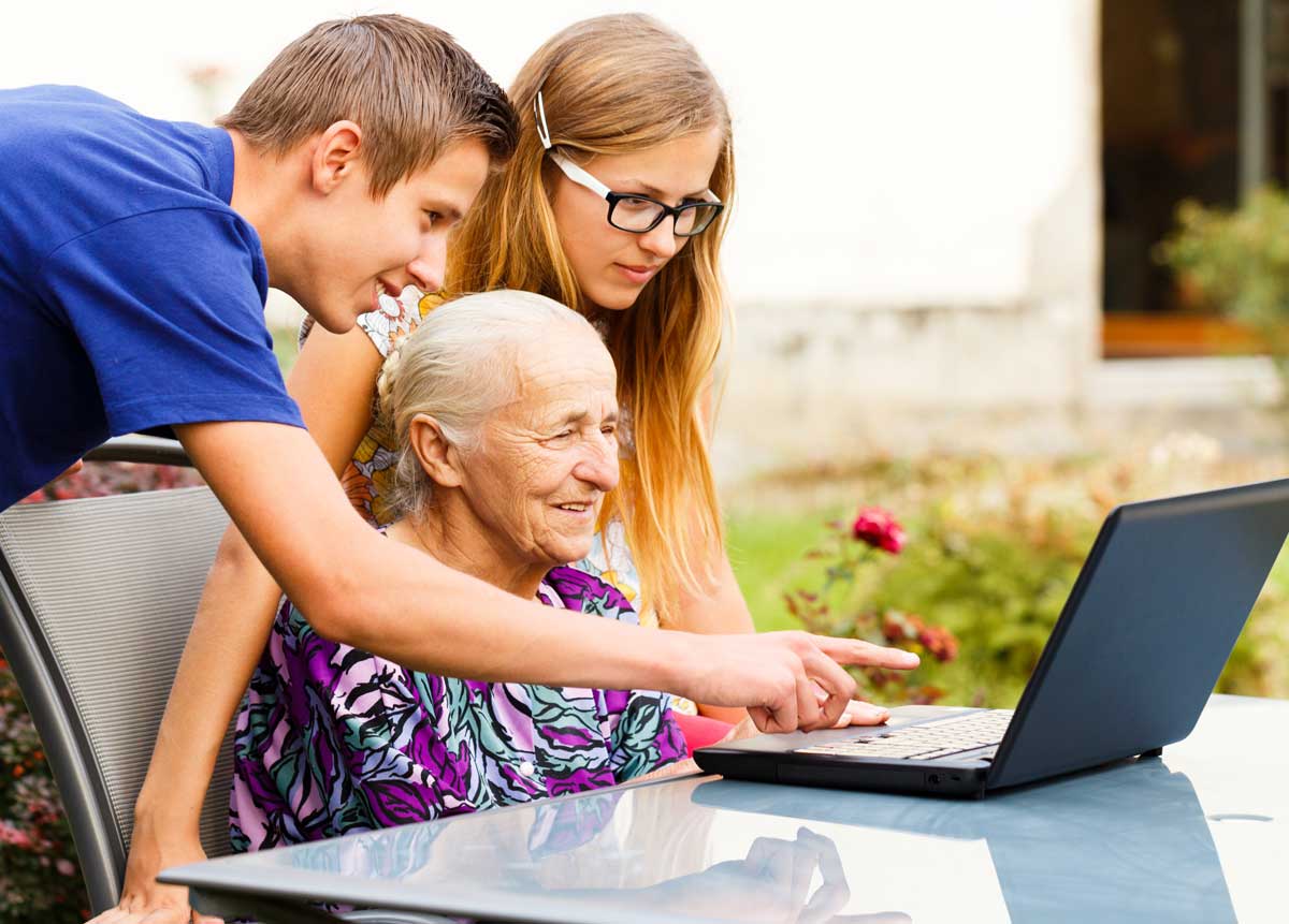 grandkids teaching grandma how to use the computer