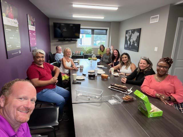 Home Instead Office Team and Care Pros sharing coffee and donuts