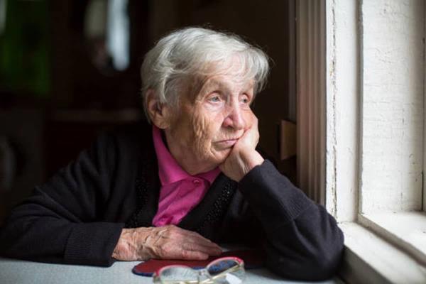 Senior woman looking out a window