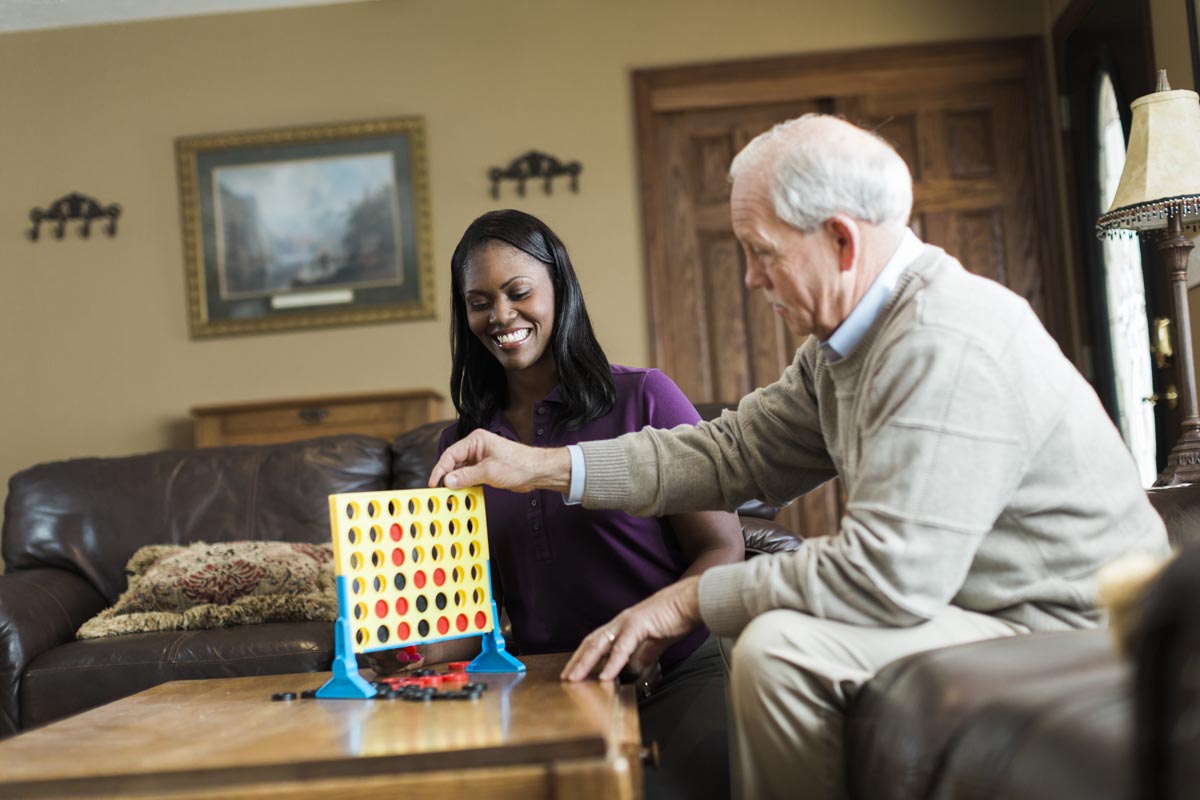 Senior playing a mind challenging agme with a Home Instead PSW