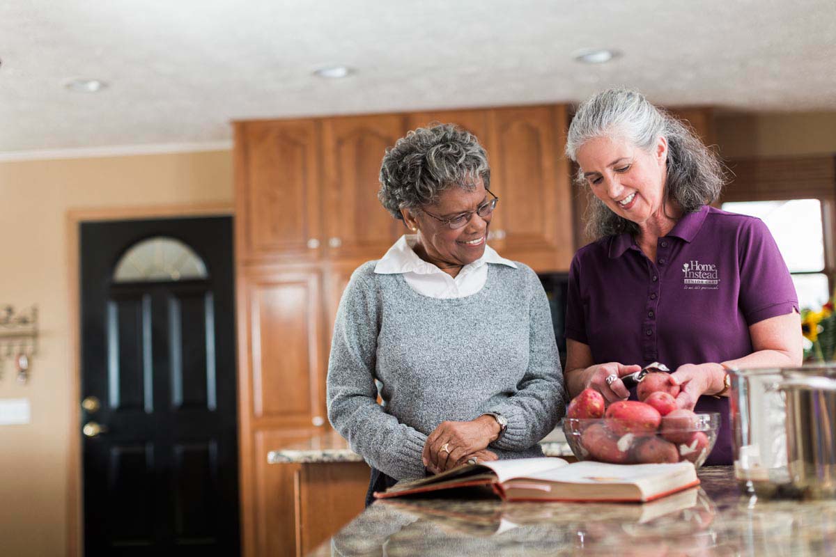 Caregiver Cooking with senior lady at her house