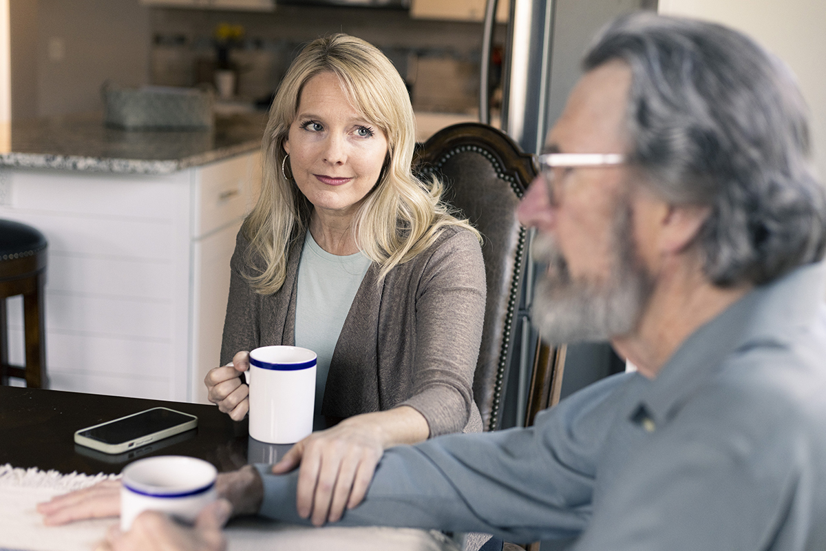 adult daughter comforting aging father