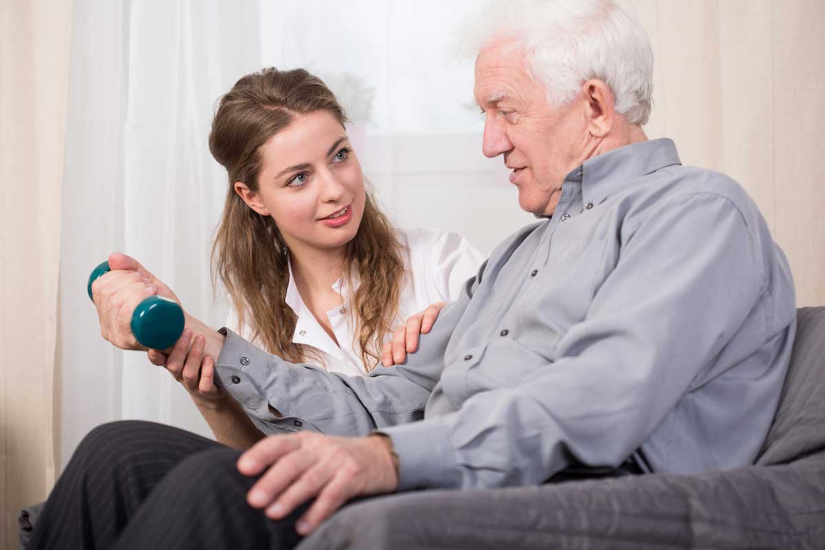 Caregiver helping and motivating senior to exercise