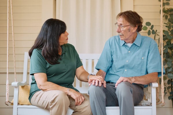 Caregiver reassuringly holds an elderly person&rsquo;s hand for comfort.