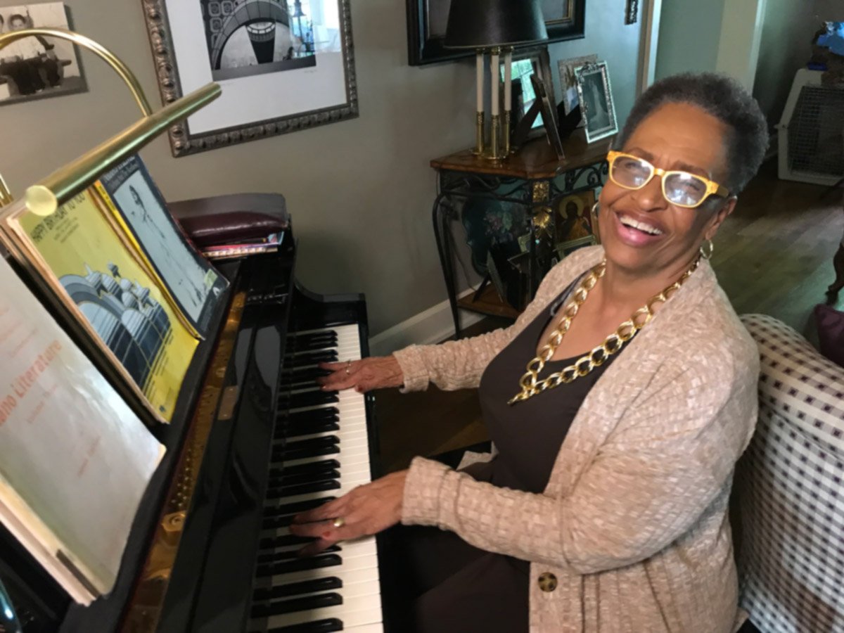 Senior woman happily playing piano at home