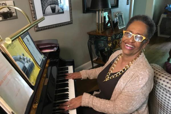 Senior woman happily playing piano at home