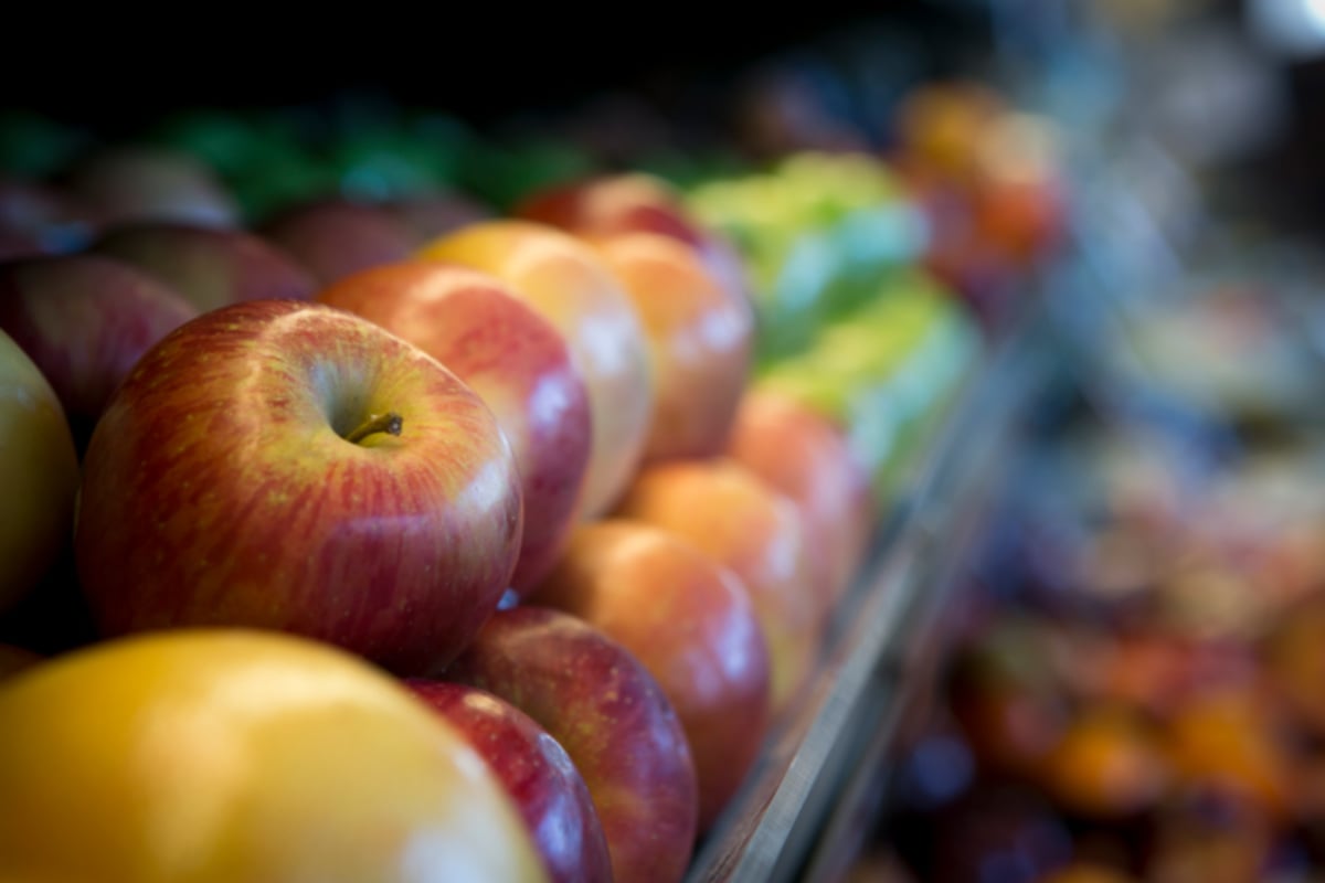 Row of apples on a grocery store shelf
