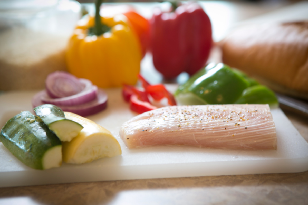 Cutting board on counter with healthy cut foods arranged on it