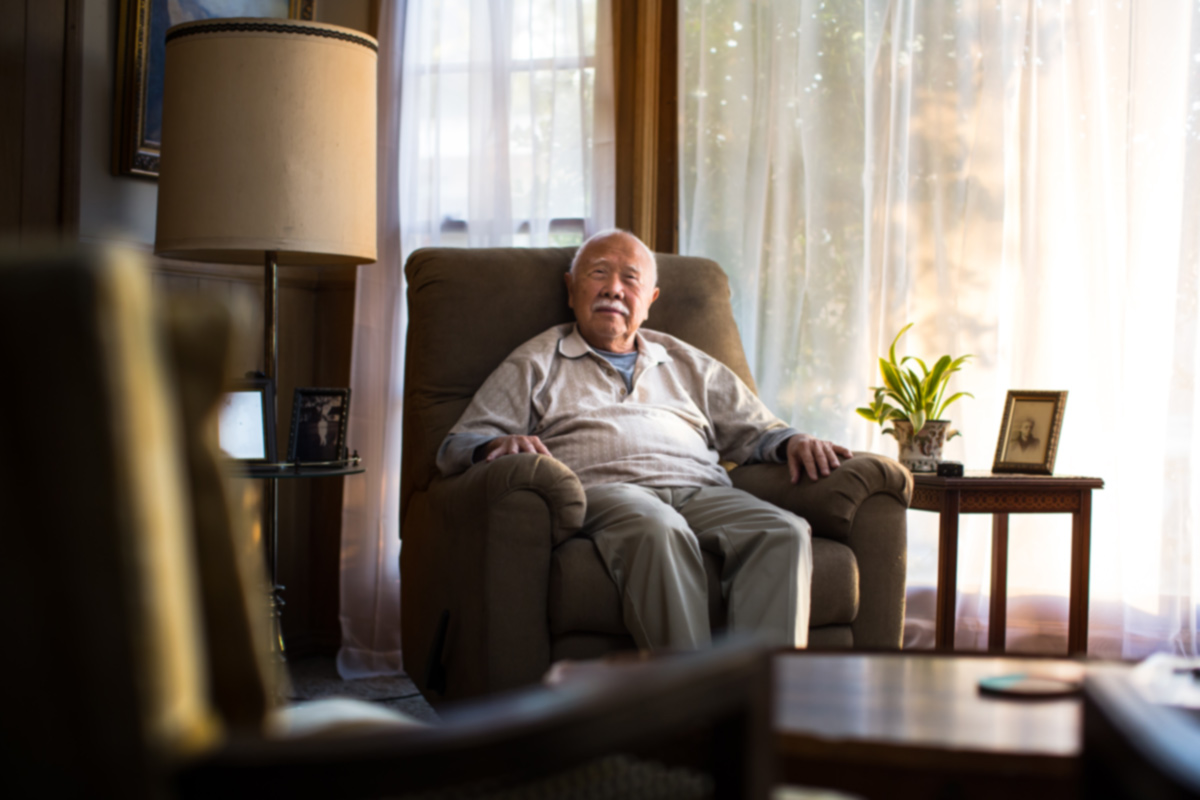 Elderly man with dementia sitting in living room chair at home