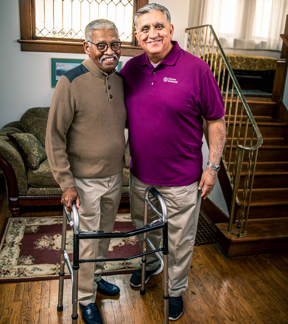 Home Instead CAREGiver and senior smiling while standing in home