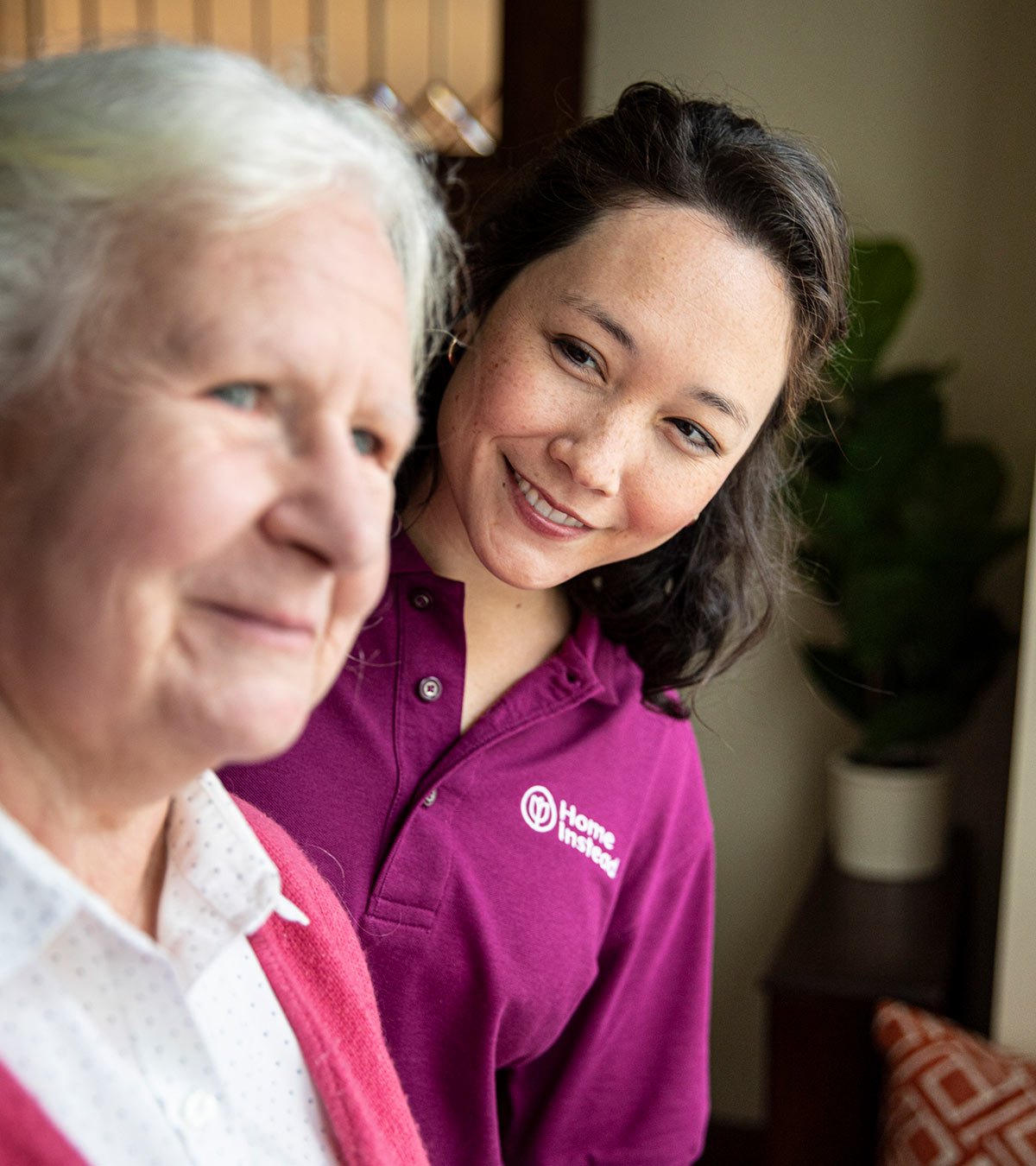 Home Instead CAREGiver smiling and looking at senior performing elder care
