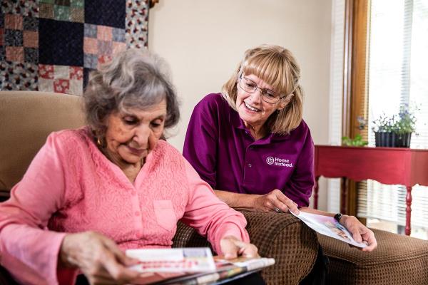 Home Instead CAREGiver and senior looking at mail