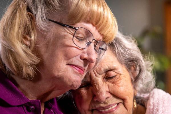 Home Instead CAREGiver and senior sitting together compassionately