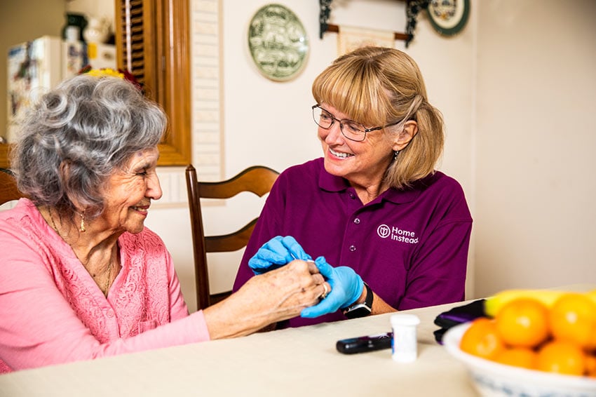 Home Instead CAREGiver helping senior with medication